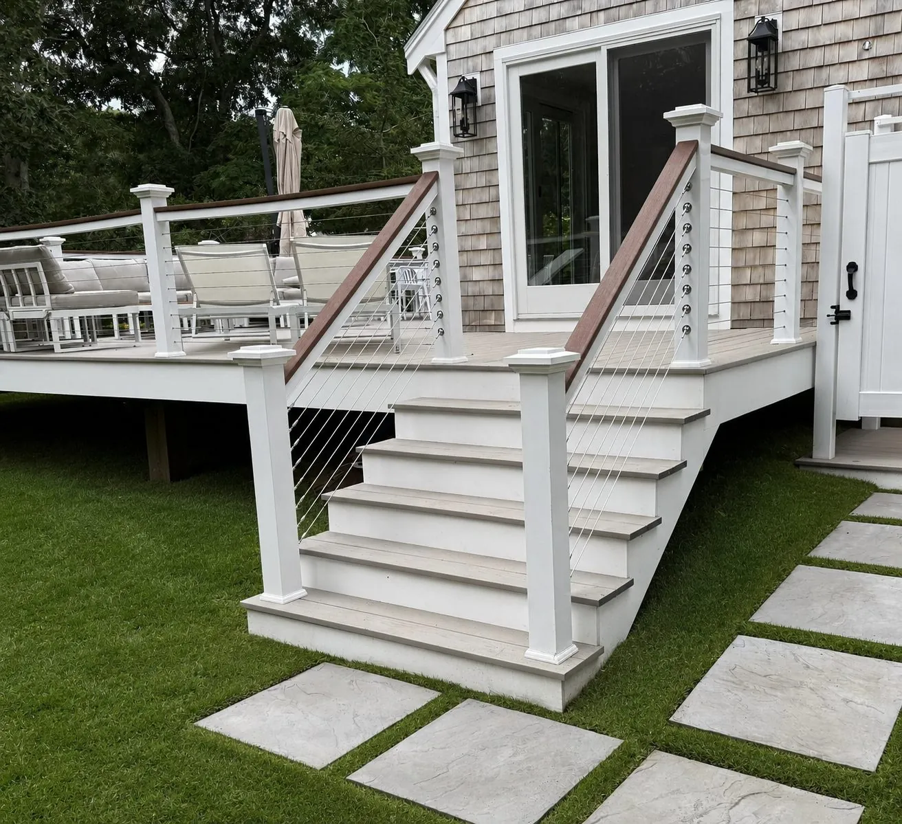 After: composite deck with white cable-rail stairs